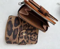 Billetera pequeña con cierre de cremallera y solapa con broche a presión.