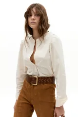 Camisa de corduroy color crudo, con cuello mao, cierre frontal con botones de nácar, mangas largas y detalle de tablas en los hombros que aportan volumen.