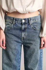 Pantalón de jean tiro medio, wide leg y extra largo, confeccionado en tejido liviano 100% algodón de tono mid blue con sutil localizado.