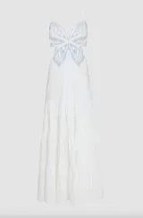 Vestido largo blanco de popelina, con diseño de mariposa bordada en azul en el busto y tirantes finos. Presenta una falda larga de tres niveles fruncidos y aberturas laterales en la cintura.