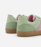 Championes de estilo retro tipo chutera, confeccionados en poliuretano color marrón con detalles en beige en los laterales y el talón. Presentan suela plana de goma color caramelo y cierre mediante cordones.