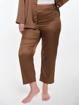 Pantalón de pijama de satén con caída fluida, corte recto y cintura elástica. Presenta un acabado suave y sedoso al tacto.