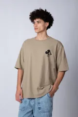 Remera negra de corte oversize confeccionada en algodón pesado, con estampa pequeña de Mickey Mouse en el pecho y diseño gráfico en la espalda.