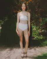 Vestido de red macramé negro hecho a mano en hilo de seda vegano con terminaciones en piedras naturales. Tiene tiras desmontables para usarlo como strapless o como falda.