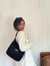 Bandolera morral color marrón, con asa de hombro y correa regulable. Cuenta con un bolsillo frontal con cierre y otro bolsillo trasero con cierre.