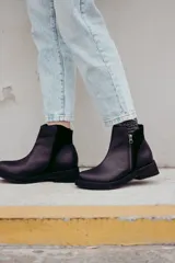 Bota corta de cuero negro con diseño minimalista, cierre lateral metálico y taco bajo cuadrado de 4 cm.