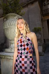 Vestido largo de tul con estampado de cuadrados de terciopelo multicolor, cuello halter atado a la nuca y aberturas laterales en la cintura.