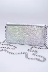 Cartera negra con textura símil cocodrilo y cadena metálica plateada.