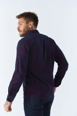 Camisa de manga larga confeccionada en pana de algodón con estampado de cuadros en tonos azul y bordó. Presenta cuello clásico, cierre frontal con botones y ajuste regular.