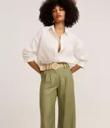 Pantalón wide leg de tiro alto color verde militar, confeccionado en mezcla de viscosa y lino, con pliegues frontales y trabillas en la cintura. Incluye un cinturón de rafia sintética con hebilla redonda.