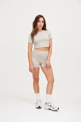 Calza corta color beige, de tiro medio y corte ajustado.