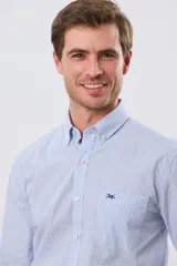 Camisa de manga larga con estampa de cuadros pequeños en tonos celeste y blanco, cuello con botones y bolsillo ojal en el pecho con detalle bordado.