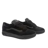 Championes Vans modelo Hylane Mono de perfil bajo y diseño voluminoso, confeccionados en gamuza negra con acabado texturizado. Presentan lengüeta sobredimensionada, cuello acolchado y la clásica banda lateral de la marca en tono sobre tono.