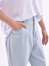 Jean de mujer color negro lavado, tiro alto, con corte mom fit holgado y puños doblados.