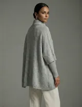 Capa tejida color fucsia, con cuello alto abotonado y mangas cortas estilo japonesa. Tejido de punto grueso.