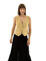 Chaleco de gamuza color beige, con cuello en V, cierre frontal con botones dorados y bolsillos ojal en el frente.