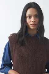 Chaleco de punto con textura afelpada, cuello redondo y hombros marcados. Presenta una silueta relajada y un diseño sin mangas.