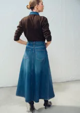 Falda larga de denim azul, corte evasé y tiro alto, con costuras pespuntadas y diseño clásico de cinco bolsillos.