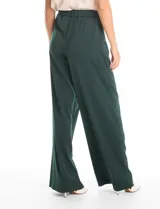 Pantalón palazzo de satén color verde oscuro, con tiro alto, pretina delantera con pasadores, cierre y botón, y pretina trasera elastizada. Cuenta con bolsillos verticales delanteros y corte amplio.