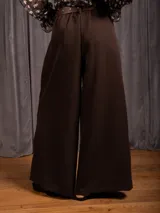 Pantalon tipo palazzo de corte amplio y tiro alto, con pinzas frontales, bolsillos laterales y cintura elástica.