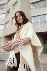 Ruana tejida en lana merino color ladrillo, con textura de punto grueso.