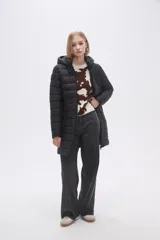 Campera acolchada color beige, de corte largo, con capucha y cierre frontal con cremallera.