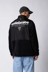 Campera de polar con recortes en tela técnica tipo sire en la parte superior frontal. Presenta cierre frontal completo, cuello alto y bolsillos funcionales en el pecho. Diseño bicolor en tonos verde oliva y negro con logo de la marca en el pecho.