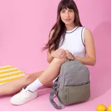 Mochila roja de nylon resistente con detalle en simil cuero. Tiene cierre principal, bolsillo frontal, bolsillo trasero con cierre y bolsillos laterales. Las correas son a tono.