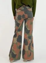 Pantalon de denim con diseño de camuflaje en tonos verde, gris y marrón. Presenta un corte recto y amplio, con terminaciones deshilachadas en el ruedo.
