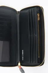 Billetera grande de nylon color negro con cierre perimetral de cremallera. Presenta un tirador de cordón bicolor con terminales metálicos y el logo de la marca estampado en dorado en el frente.