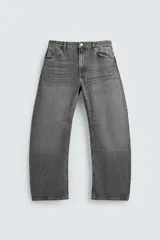 Jeans de denim de algodón en color negro con efecto lavado, corte amplio y silueta curva tipo barrel fit con pinzas en las rodillas. Presenta diseño clásico de cinco bolsillos y cierre frontal con cremallera y botón metálico.