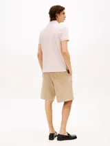 Chomba Tommy Hilfiger de corte regular, color rosa claro, con cuello tipo polo y tapeta de dos botones. Logo bordado en el pecho.