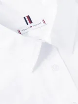 Vestido camisero de corte oversize confeccionado en algodón orgánico. Presenta cuello inglés, cierre frontal de botones, mangas largas con puños abotonados y largo hasta la rodilla. Incluye el logo de la marca bordado en el puño.