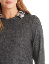 Buzo de tejido fino color beige con diseño de doble capa que simula una camisa debajo. Presenta cuello redondo, mangas largas con puños de gasa estampada en animal print, y ruedo con volado de la misma tela. Incluye detalles de frunces en los laterales.