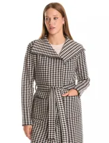Chaqueta larga de tejido de punto con estampado de pata de gallo en blanco y negro. Presenta cuello de solapa, cierre frontal con lazo ajustable en la cintura y bolsillos aplicados en el frente.