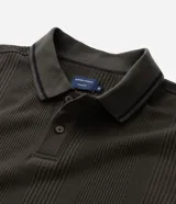 Remera polo blanca de viscosa texturizada con rayas, cuello y puños de mangas cortas en ribana con detalles contrastantes en negro.