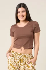 Remera básica de manga corta y cuello redondo, con diseño cropped y detalle de abertura central en el ruedo.