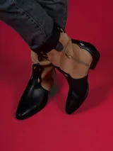 Botas de caña baja color negro con detalles en beige y cierre lateral.