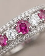 Anillo ancho de plata 925 con diseño pavé, adornado con piedras naturales de rubí en tono fucsia alternadas con circonias blancas.