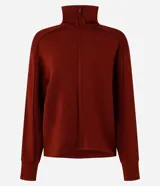 Campera deportiva negra confeccionada en microfibra pesada, con cuello alto doblado, cremallera delantera con cordón en el tirador y puños ajustados.