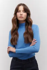 Polera de tejido morley color azul, con cuello alto y mangas largas, de corte ajustado al cuerpo.