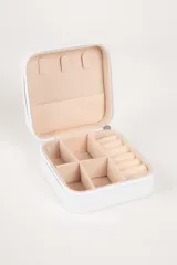 Caja organizadora de joyas blanca con interior de terciopelo color crema, con compartimentos para anillos, collares y aros.