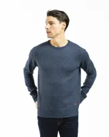 Buzo tejido de punto con cuello redondo, mangas largas y puños acanalados. Presenta un diseño liso en tono azul jaspeado con un pequeño detalle de etiqueta en el ruedo.