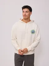 Canguro color crema con efecto lavado, confeccionado en mezcla de algodón y poliéster. Presenta un estampado circular en el pecho con motivos de sol y el logo de Rusty.