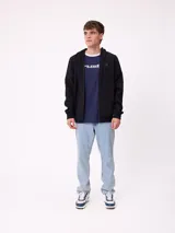 Canguro azul marino con capucha, cierre frontal, bolsillos tipo canguro y logo de la marca en el pecho.