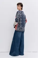 Cardigan de punto con diseño jacquard estilo patchwork en tonos azul, rojo y crema. Presenta un estampado tipo bandana, cuello en V, cierre frontal con botones y mangas largas.