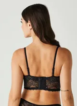 Soutien tipo corset negro, con copas con aros y tirantes finos ajustables. El cuerpo es de encaje con paneles de transparencia y un bajo con borde festoneado.