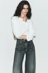 Jeans de tiro alto y estilo extra wide leg, con diseño de cinco bolsillos y lavado desgastado. Cuenta con cierre frontal con cremallera y botón metálico.