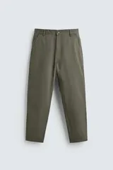 Pantalón de corte carrot fit confeccionado en tejido de algodón con estructura diagonal y efecto lavado. Presenta bolsillos frontales con bolsillo cerillero, bolsillos traseros de plastrón y cierre frontal con cremallera y botón.