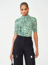 Blusa de mangas cortas con cuello alto y estampado animal print en tonos verde y blanco.